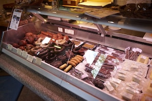 A deli counter with various meats and cheeses displayed in a glass case. - Rhön-Indianer-Hotel (Poppenhausen)