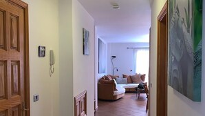 A hallway leading to a living area with a sofa and a lamp. - Playa San Juan, a large apartment with 3 bedrooms, for families, group  (Playa San Juan)