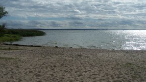 Una playa con orilla arenosa y agua tranquila.