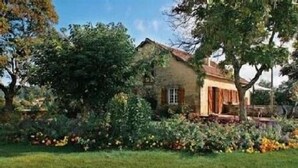 Une maison de campagne avec un jardin à l’avant.