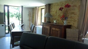 Un coin repas comprenant une table, des chaises, une lampe et un vase avec des fleurs.