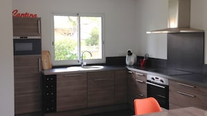 A modern kitchen with a window, built-in oven, and a stove.