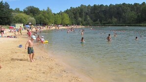 Ein Strand mit badenden und Spaziergängern im Sand.