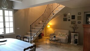 Ein geräumiges Wohnzimmer mit Essbereich, einer Treppe und einem gemütlichen Sofa.