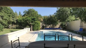 Ein Poolbereich im Freien mit überdachter Sitzgelegenheit und Blick auf die umliegende Landschaft.