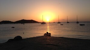 Atardecer sobre un mar tranquilo con varias embarcaciones ancladas.