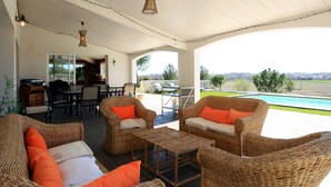 An outdoor patio with wicker furniture, a pool, and a view of the landscape.