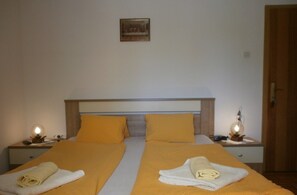 Un lit double avec deux oreillers et deux tables de chevet avec des lampes.
