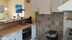A compact kitchen with white cabinets, a wooden countertop, and a tiled backsplash. - house 4/5 pers near lake and ocean (HOURTIN)