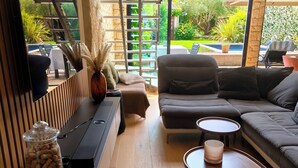 Uma sala de estar moderna com um sofá, mesa de centro e uma TV em uma parede de madeira.