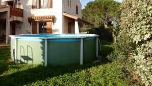 Une maison avec une piscine, un balcon et un jardin.