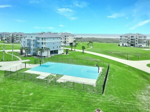 A residential complex with multiple apartment buildings, a basketball court, and surrounding green spaces. - Playa Blanca -Beach Front-Ocean View- 3BD/2BA. Sleeps 9 (Galveston)