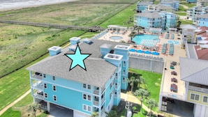Un hôtel situé sur la côte, composé de plusieurs bâtiments bleus, avec un accès direct à la plage et un espace piscine.