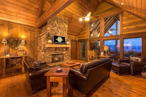 Warm and Welcoming Living Area with Massive Stone Fireplace and Wall of Windows