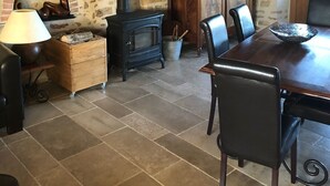 Ein rustikaler Essbereich mit Kamin aus Backsteinen, Holzmöbeln und einer Steinwand.