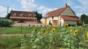 Ein zweigeschossiges Haus mit Satteldach und umzäunter Garten.