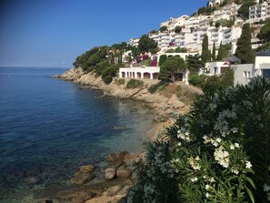 A coastal town with buildings on a hillside overlooking the sea. - Waterfront apartment with magnificent views over the bay of ROSAS (ROSES)