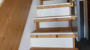 Una escalera de madera con peldaños blancos y barandilla de madera.