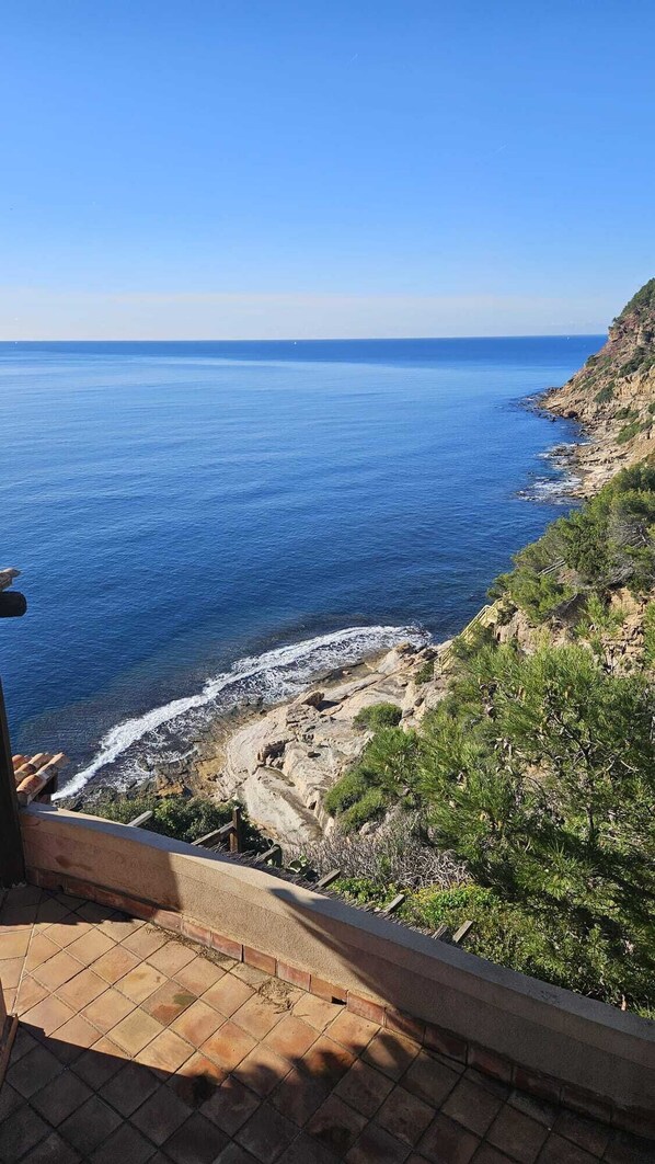 Vistes costaneres amb un litoral rocos i un cel blau clar.