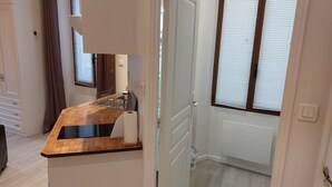 Una cocina moderna con encimera de madera, un lavamanos integrado y una ventana con persianas.