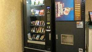 A vending machine with a beverage advertisement and snack packages. - Filmores Hotel (Toronto)