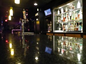 A bar area with a polished floor and shelves of bottles. - Filmores Hotel (Toronto)