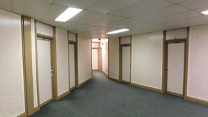 A hallway with carpeted floors and doors on both sides, leading to a room at the end. - Filmores Hotel (Toronto)