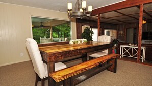 Een eetgedeelte met een houten tafel, comfortabele stoelen en een bank.