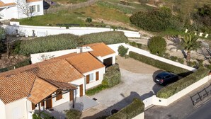 A residential property with a tiled roof, a driveway, and a car parked in the driveway.