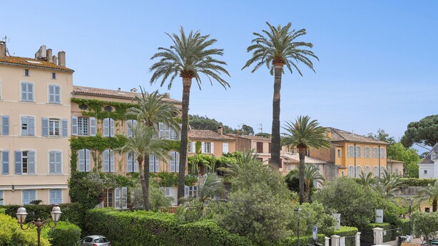 A row of Mediterranean-style buildings with shutters, palm trees, and a clear sky. - Saint Tropez, exclusive apartment, heart of the village, Place de la Garonne. (Saint-Tropez)