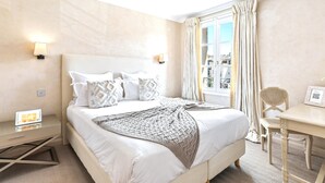 A hotel room with a large bed, bedside lamps, a desk, and a chair. - Saint Tropez, exclusive apartment, heart of the village, Place de la Garonne. (Saint-Tropez)
