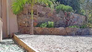 A garden area with a stone wall, pebbles, and a palm tree. - T4 - 95 m2, Porticcio, garden, garage option, large bedding 180+160. Wifi Fiber (Grosseto-Prugna)
