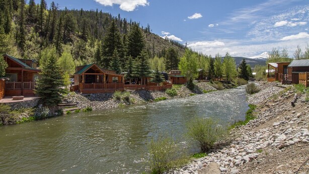 A riverside lodge with multiple cabins, surrounded by dense forest and mountains. - Cozy Cabin on the River. 1 Bed 1 Bath Patio w/  BBQ (Breckenridge)