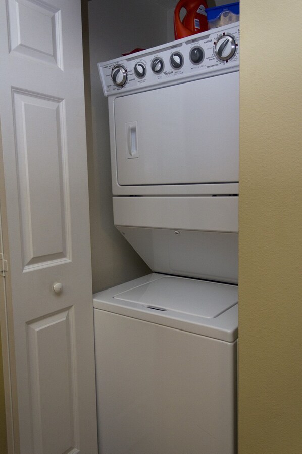 A compact laundry room with a front-loading washer and dryer.
