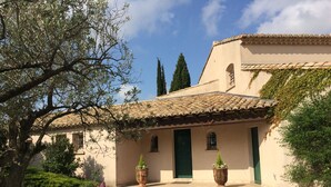 A building with a tiled roof, green doors, and potted plants. - Charming villa with private pool (Arles)