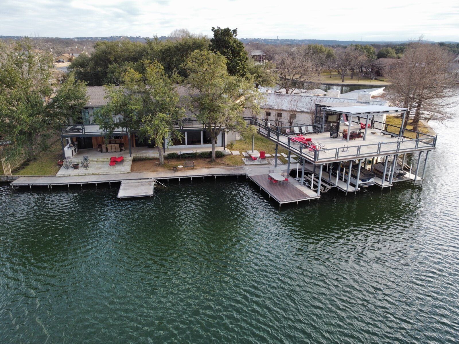 A waterfront property with a dock, outdoor seating, and a covered patio.