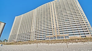 Un hotel moderno con múltiples balcones y vista al mar.