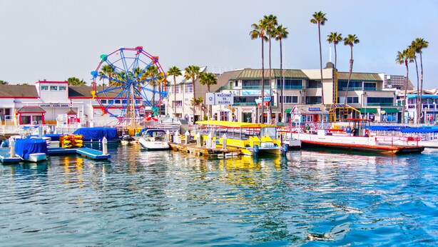 Un puerto deportivo con barcos amarrados, una noria y un edificio con un letrero que dice "Welcome to Balboa".