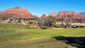 Un campo da golf con vista chiara su formazioni rocciose rosse sullo sfondo.