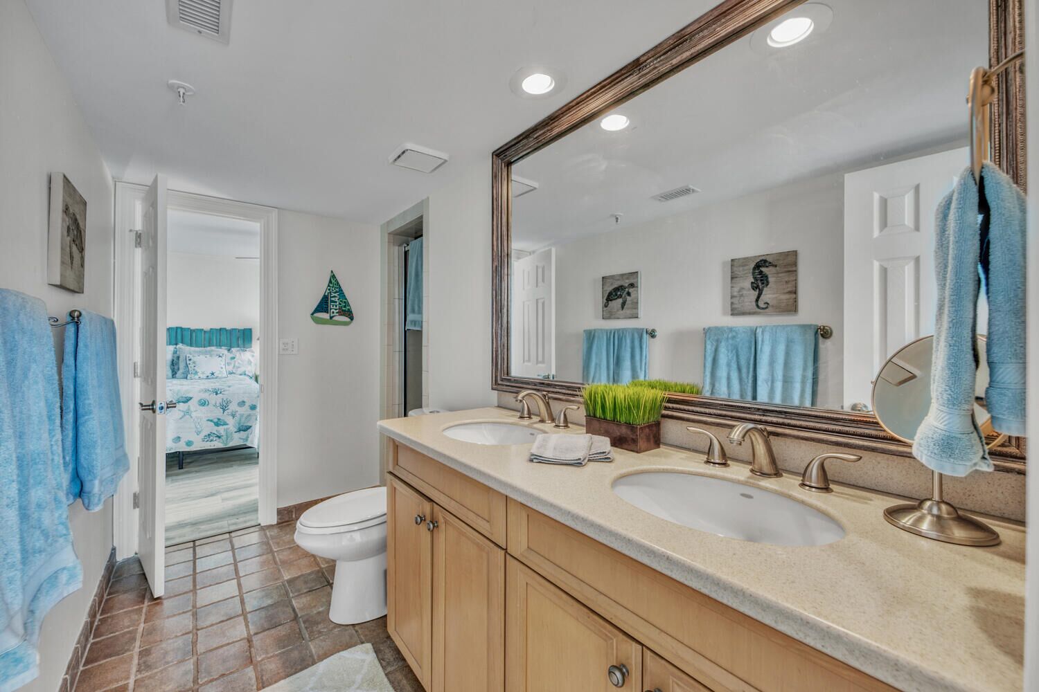 A bathroom with two sinks, a large mirror, and a toilet.