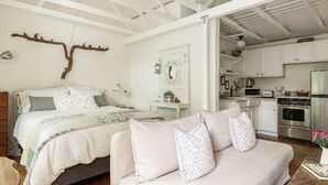 Une chambre avec un lit, un canapé et un coin cuisine.