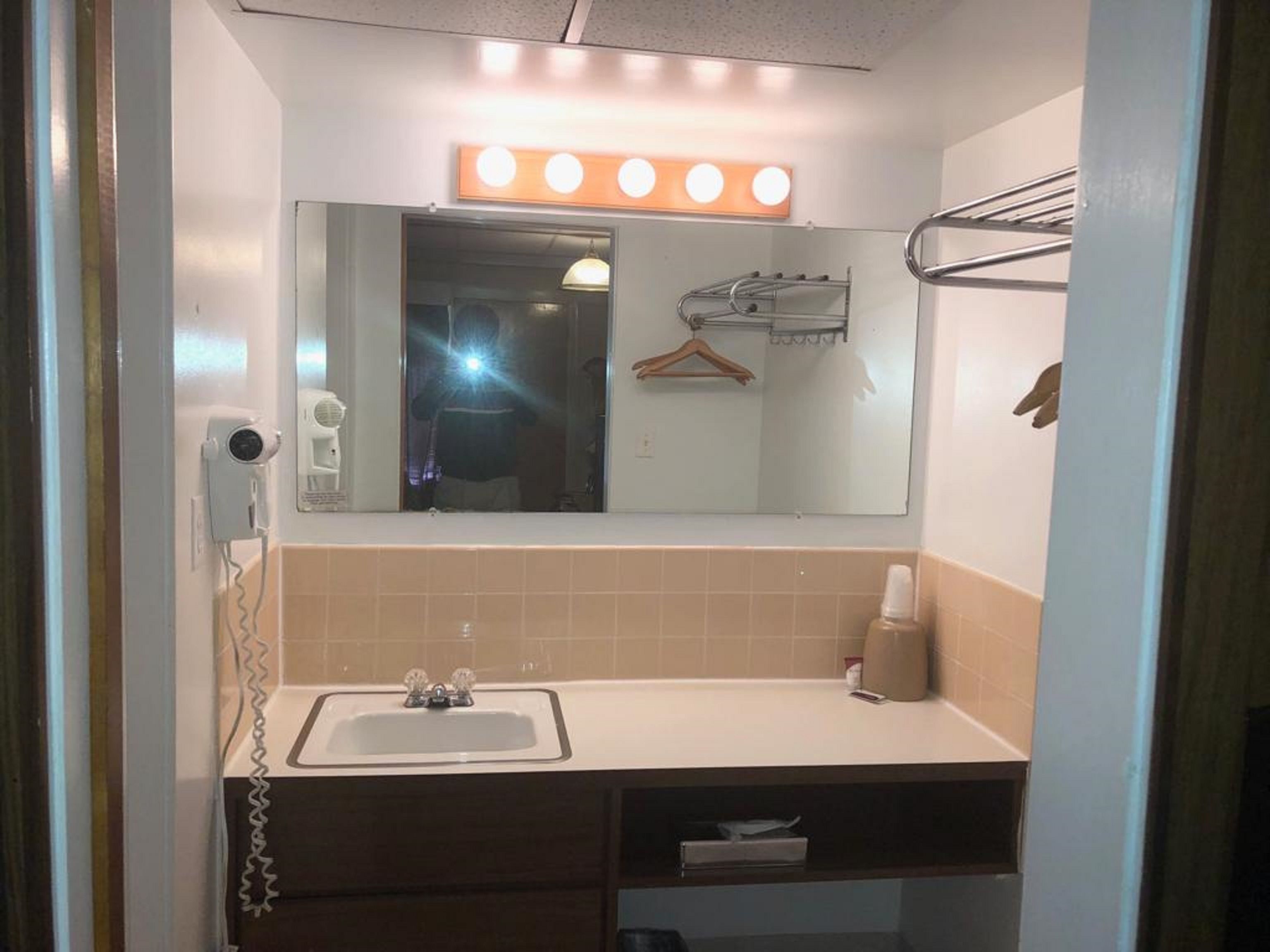 Un baño con lavabo, espejo y tocador.