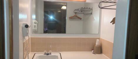Un baño con lavabo, espejo y tocador.