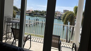 A balcony with a view of a marina, including docked boats and buildings in the background.