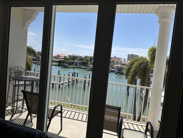 A balcony with a view of a marina, including docked boats and buildings in the background.