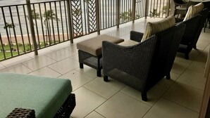 A balcony with wicker furniture, a view of the ocean, and a tiled floor. - Ocean Front Sunset & Whale-Watching Views at Hyatt Vacation Club (Lahaina)