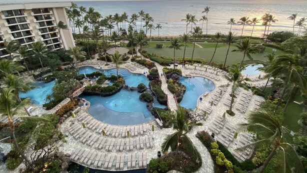 A resort pool area with multiple pools, lounge chairs, and palm trees. - Ocean Front Sunset & Whale-Watching Views at Hyatt Vacation Club (Lahaina)
