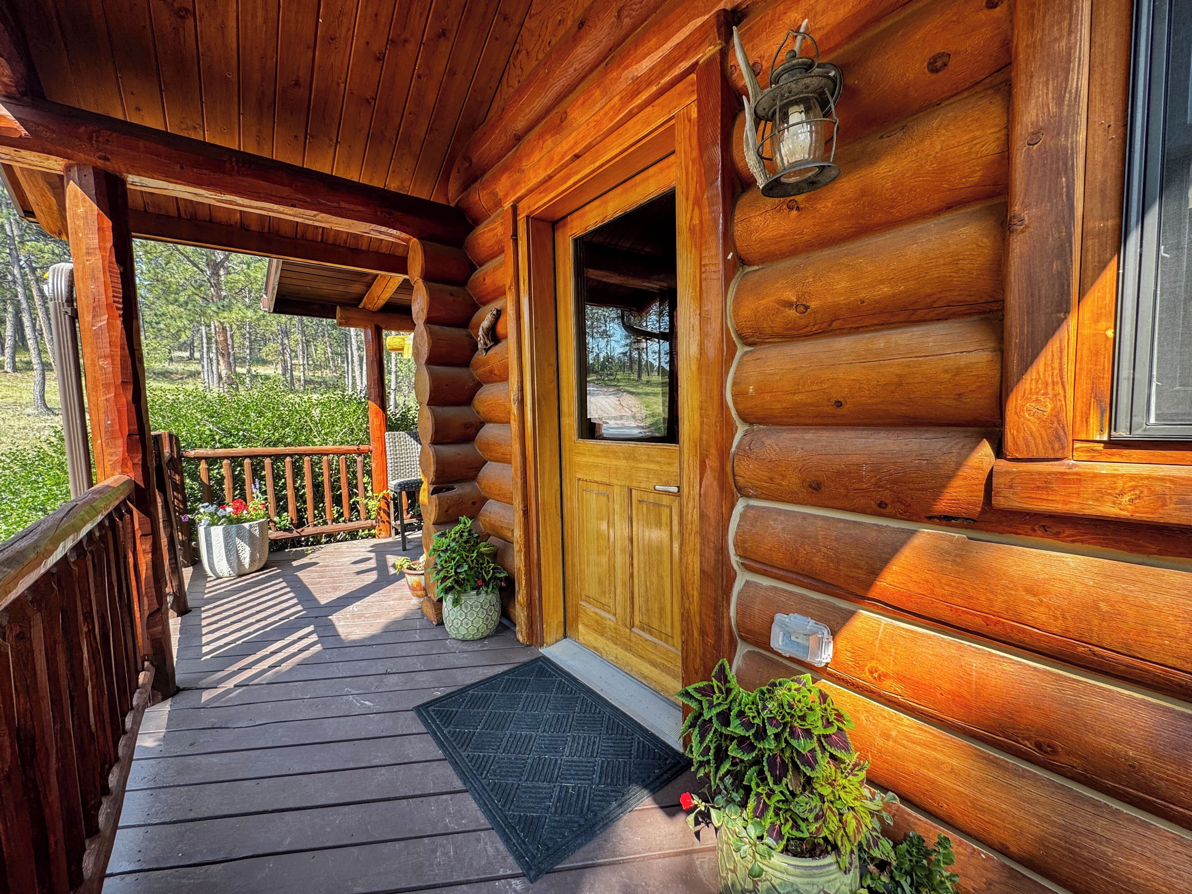 Une cabane en bois avec une véranda, une porte et une fenêtre.