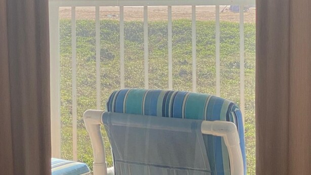 A balcony with a view of the ocean, a chair, and a railing. - Right Price in Paradise! Luxury Ocean Front (South Padre Island)