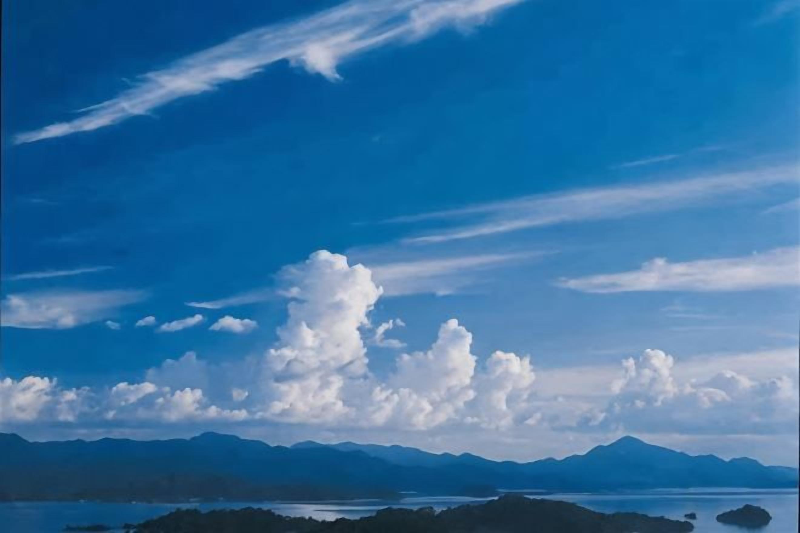 Un paysage côtier avec des montagnes à l’horizon et un ciel dégagé.